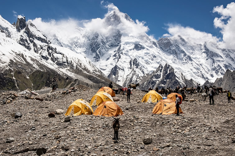 High-altitude of 8000 meters adventure in Pakistan,tents in snow covered mountains of K2 and Nanga Parbat showcasing extreme adventure tourism.